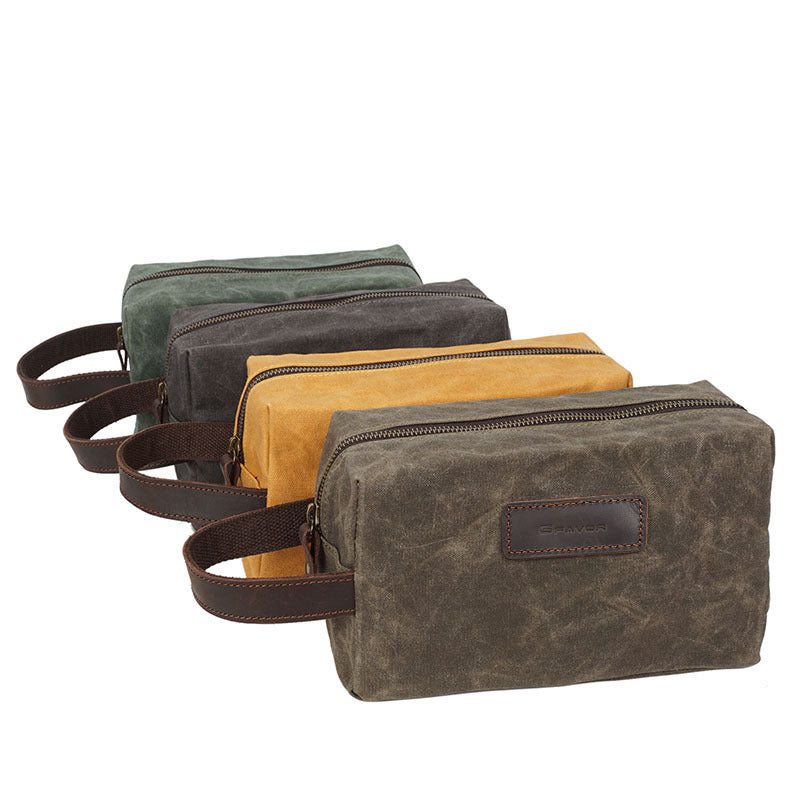The Dulwich Wrist Pouch in oil-waxed canvas with a cowhide wrist strap